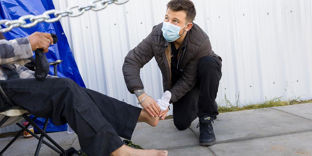 Christopher Poyorena helps an unsheltered person on a street medicine run with Street Medicine Phoenix.