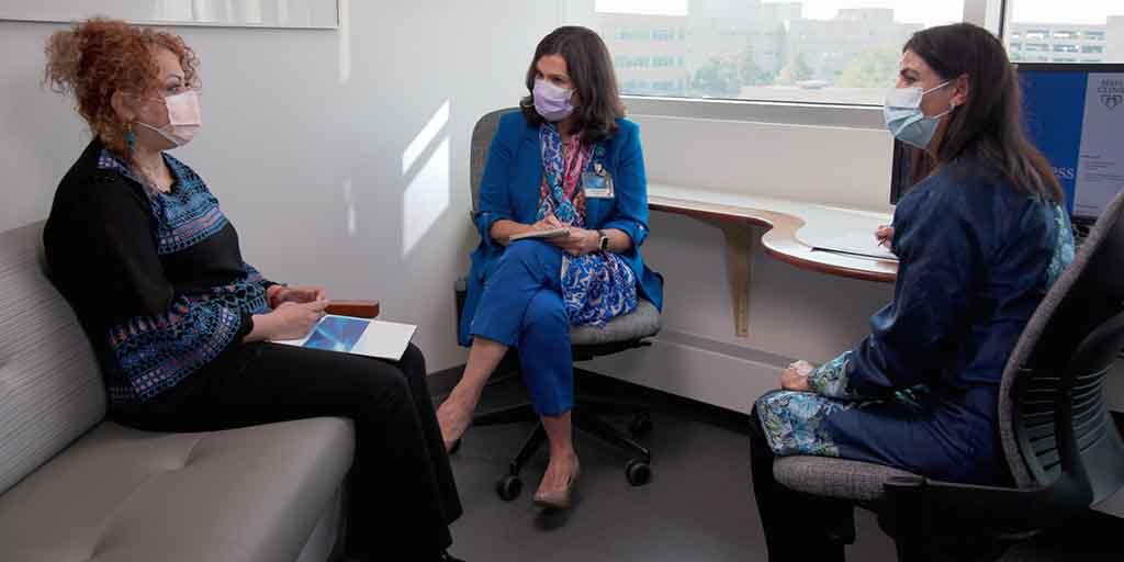 Medical student and patient sitting and talking with a professional medical interpreter