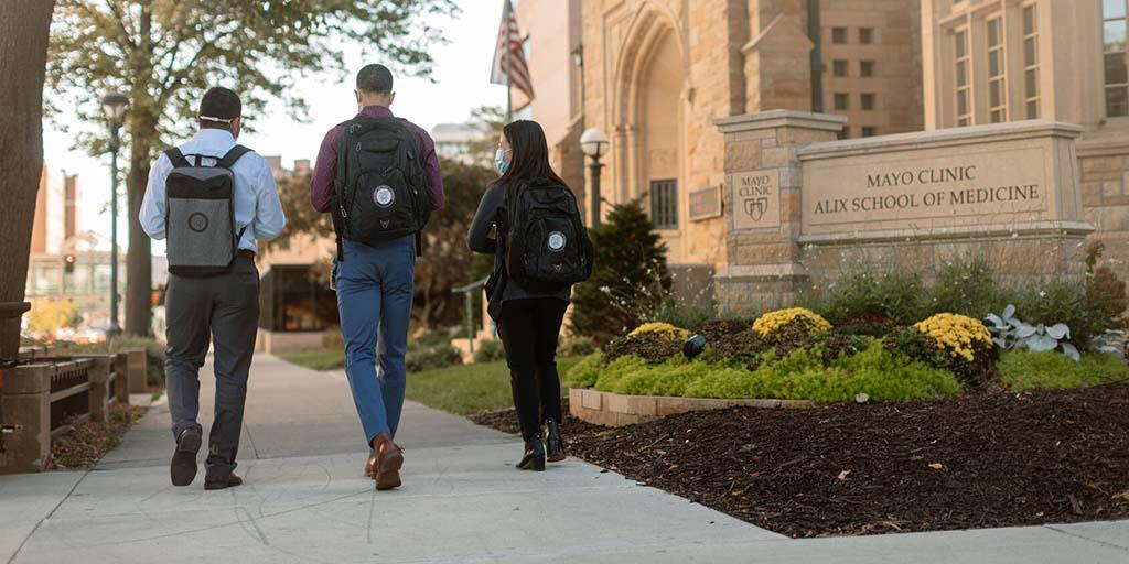 Students walking on the sidewalk in front of Mayo Clinic Alix School of Medicine building