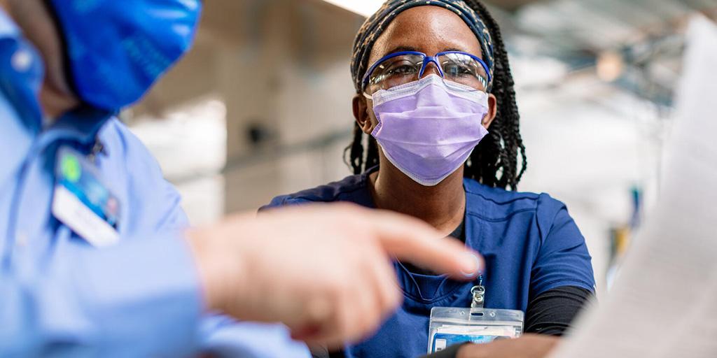 Two individuals looking at information on a computer in the clinic