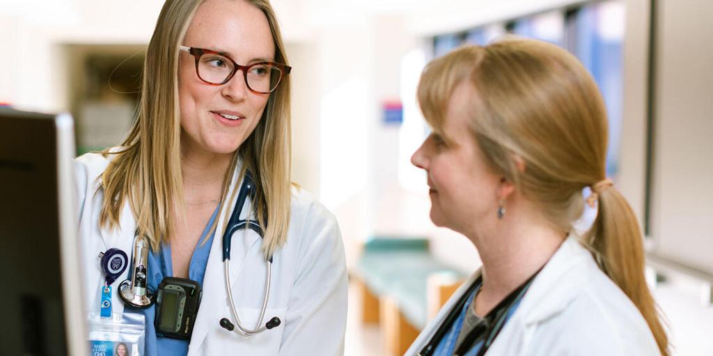 Two physicians speaking in the hallway of the hospital