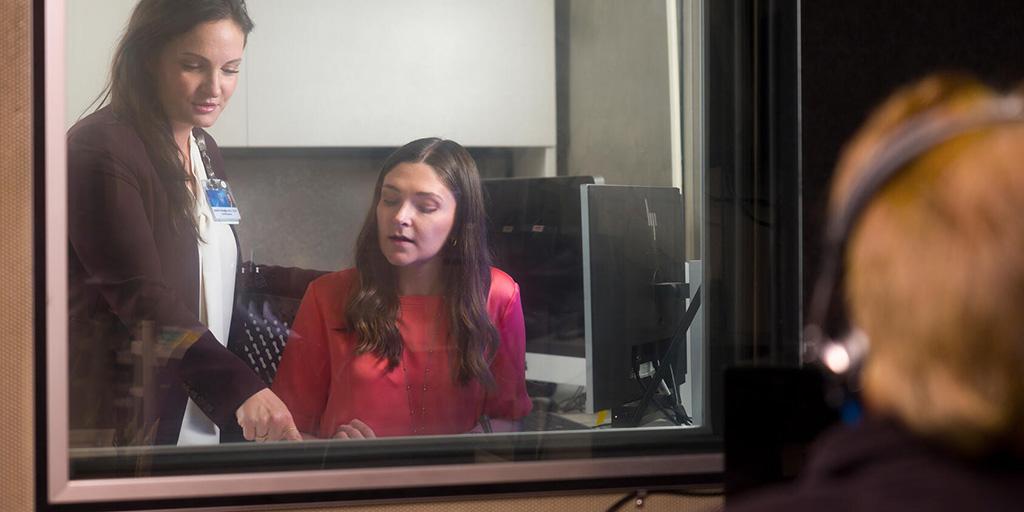Two people in audiology booth
