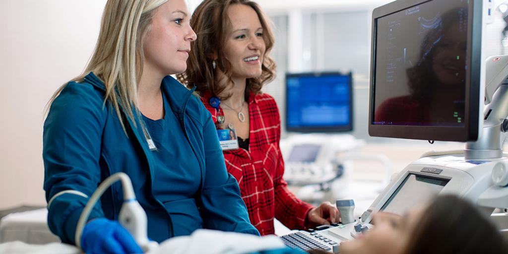 Echocardiography intern and faculty member perform a scan together.