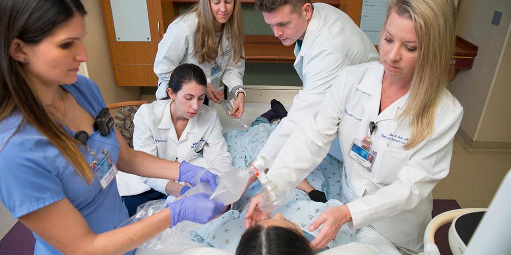Group of fellows in a patient room setting simulating a critical care emergency