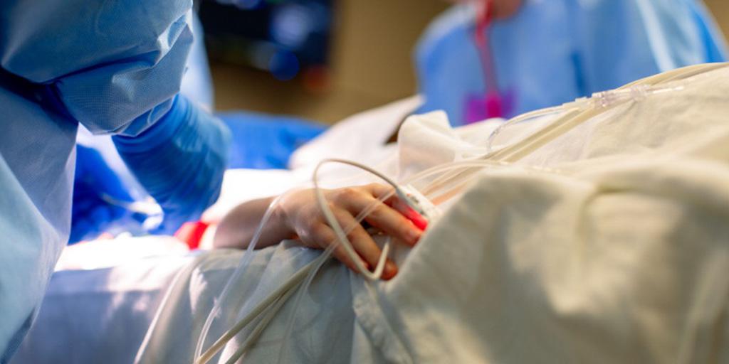Close up of a patient's hand with heart monitoring equipment on finger