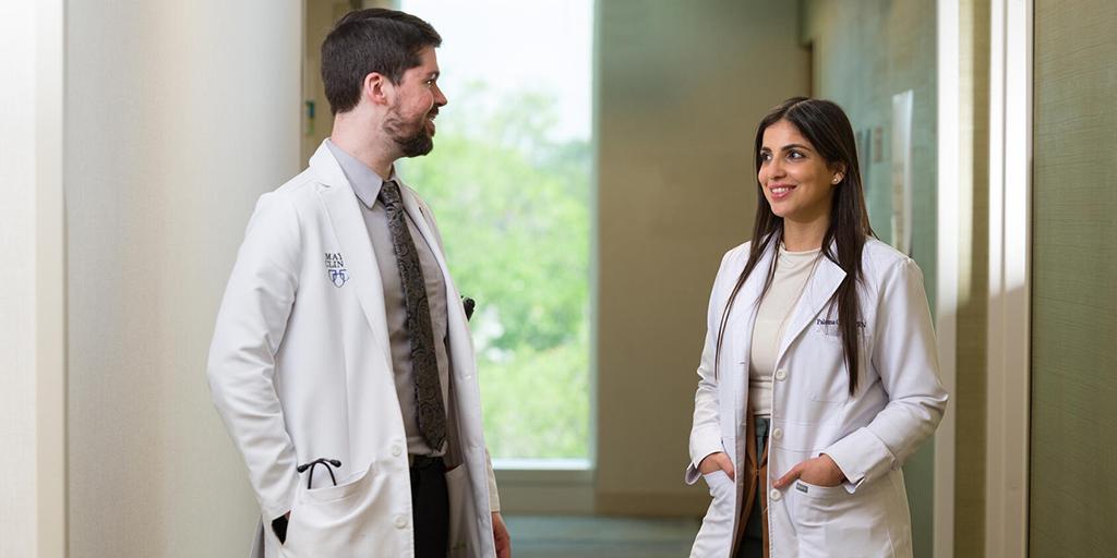 A Hematology/Oncology Physician Assistant and an Advanced Practice Providers (APP) fellow review a computed tomography (CT) imaging scan on a computer in an office together