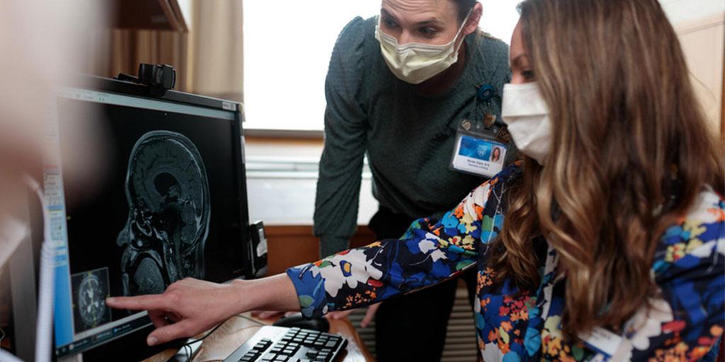 Two students sitting at a desk reviewing a brain scan