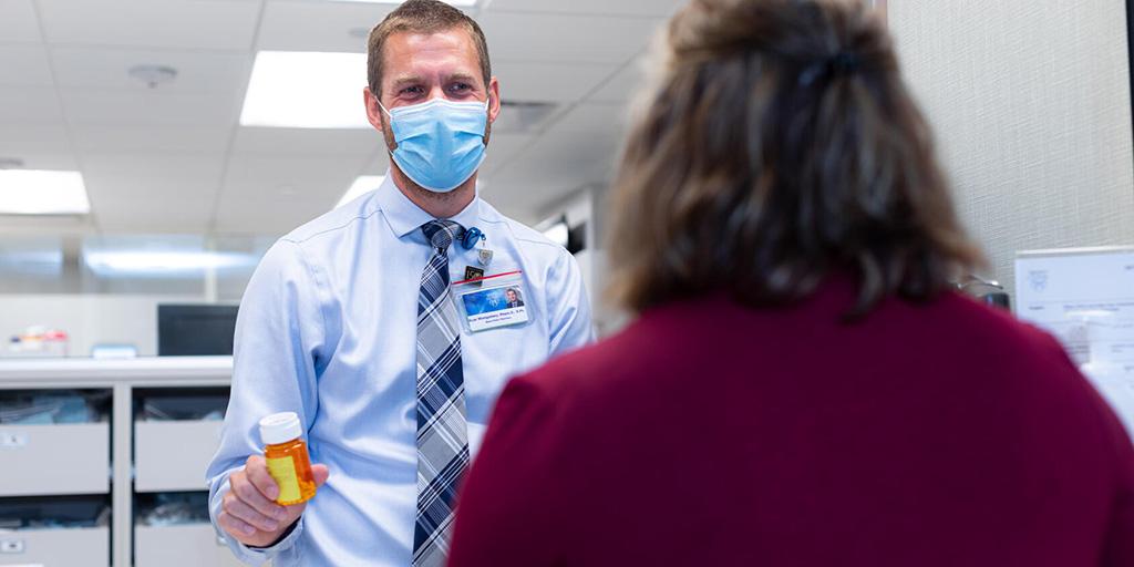 Pharmacist gives medication to a patient in the clinic