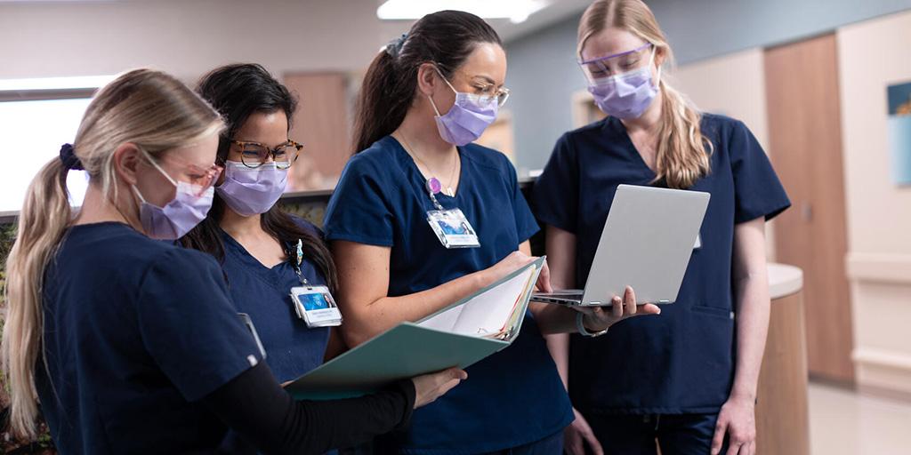 A group of RNs standing in the hallway in the hospital