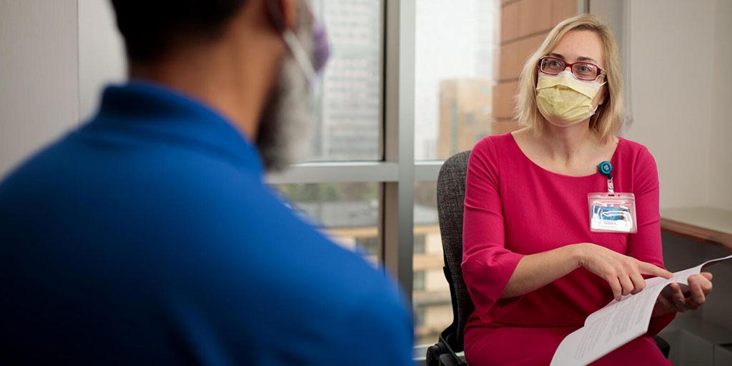 Nurse sitting in exam room and talking with patient