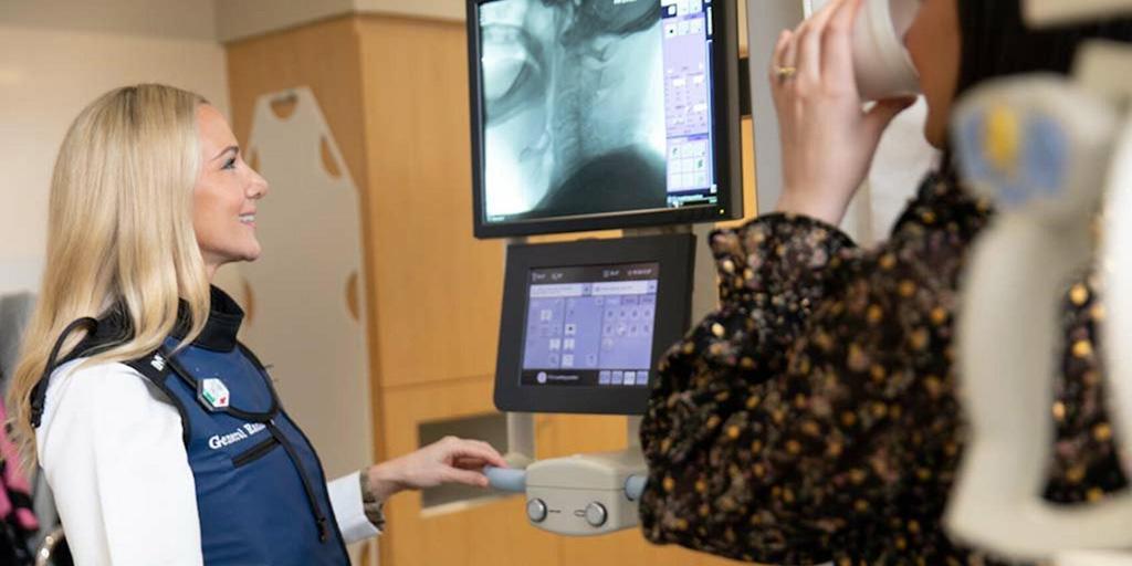 Speech language pathologist directs a patient taking a swallow study in the exam room