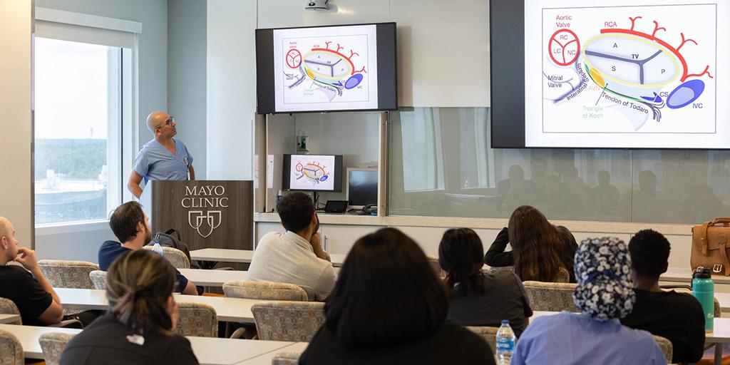 A person from the Anesthesiology Residency program in Jacksonville, Florida, in a lecture room speaking to 10 people sitting in the audience.