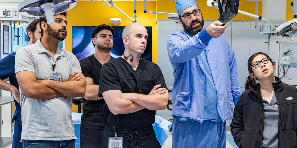 Six people from the Anesthesiology Residency program in Jacksonville, Florida, working in the lab, watching a monitor