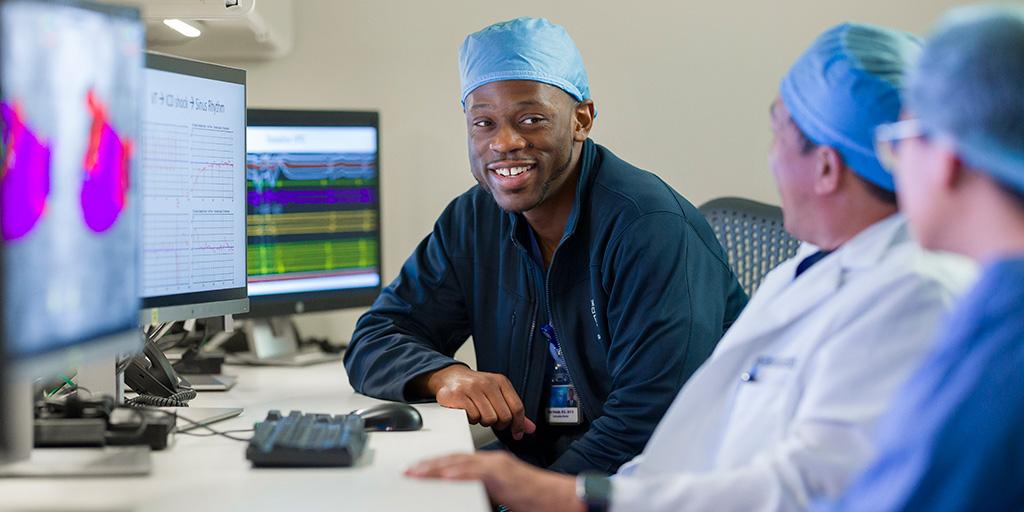 Three fellows from CCEP Fellowship in Arizona look at images on computer screen