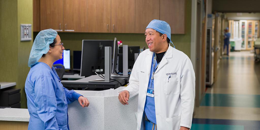 Two fellows standing at a desk in hallway