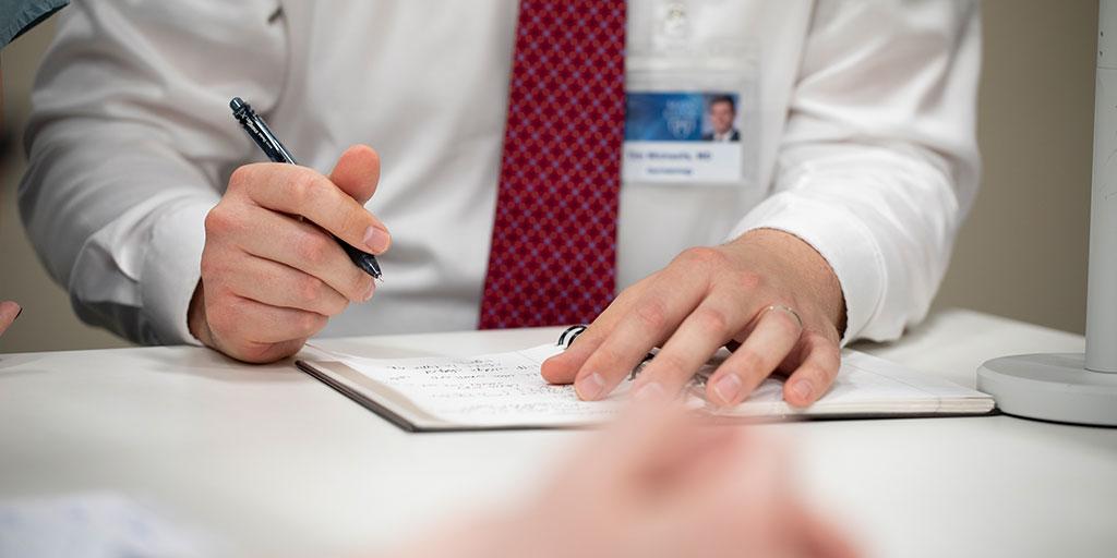 Person writing on a piece of paper