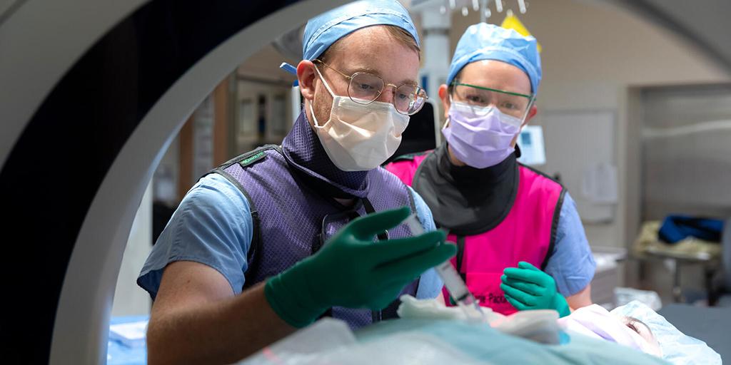 Two residents from the Diagnostic Radiology Residency program in Rochester, Minnesota, perform a procedure in a lab.