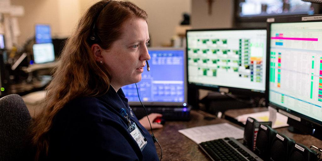 An emergency communications officer answers calls at the computer