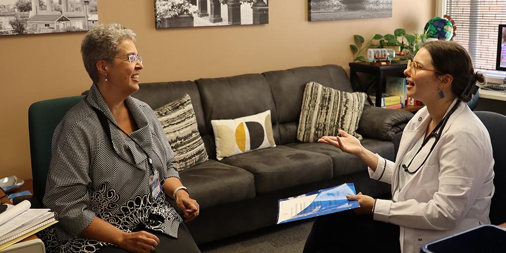 Doctor confers with patient in office.