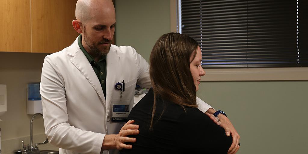 Doctor working with patient's shoulders.