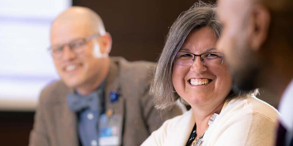 General Internal Medicine (GIM) staff at a conference table have a discussion.