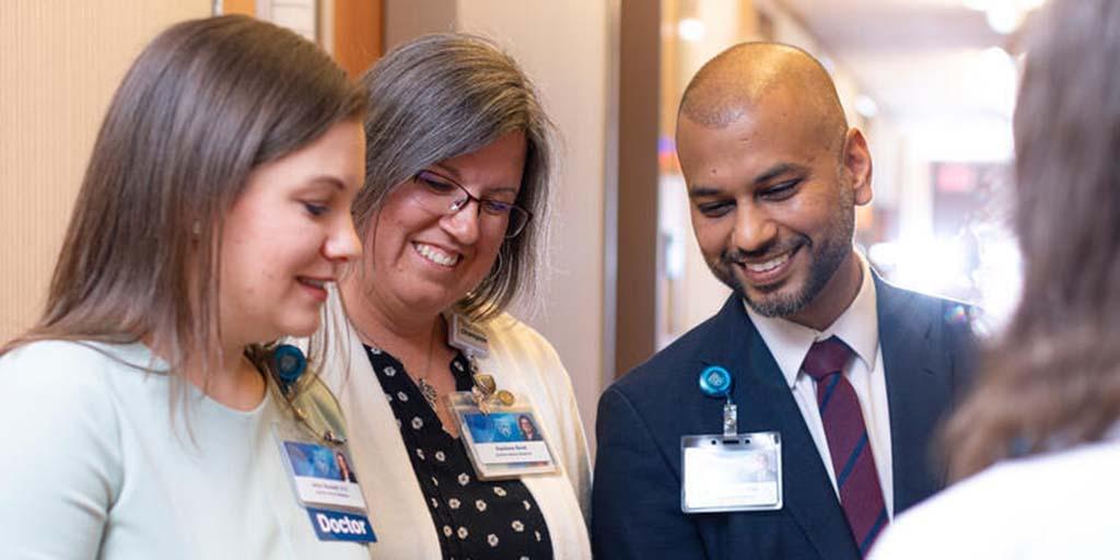 General Internal Medicine (GIM) staff collaborating on patient care in a corridor.