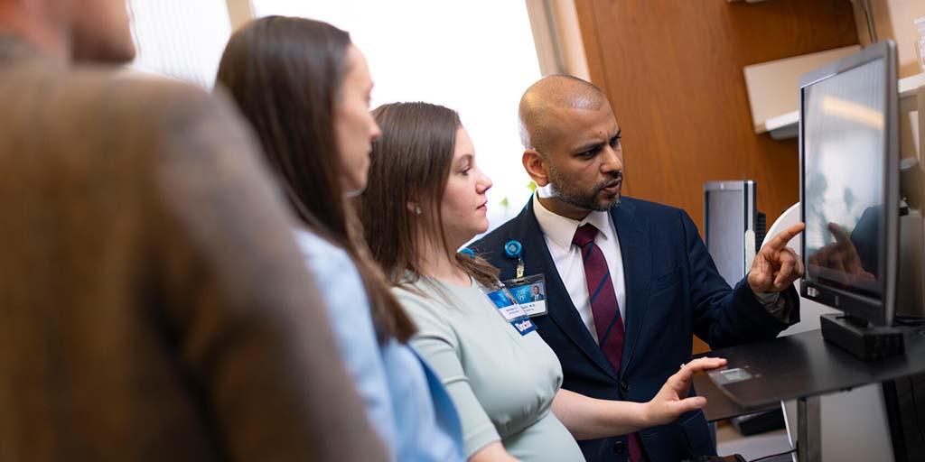 General Internal Medicine (GIM) staff review diagnostic data on a monitor together.