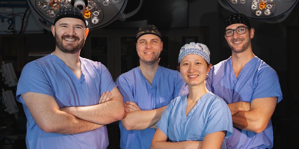 Four doctors from the General Surgery Residency program at Mayo Clinic in Phoenix, Arizona posed for a group photo in an operating room.