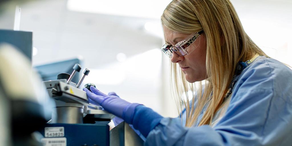 A pathologist inserting a sample into a piece of equipment in the pathology lab at Mayo Clinic