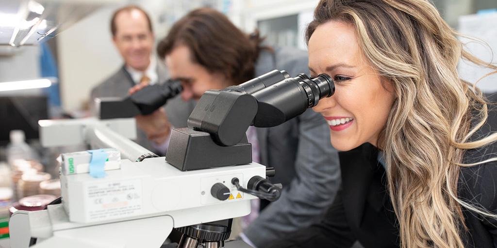 An infectious diseases fellow looks through a microscope in a lab at Mayo Clinic in Arizona