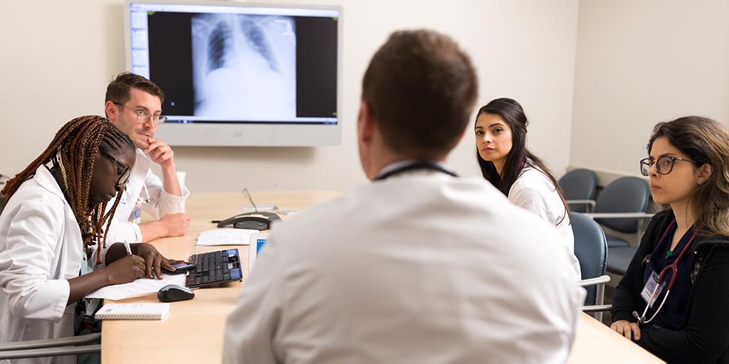 Internal medicine residents and faculty look at scans together.