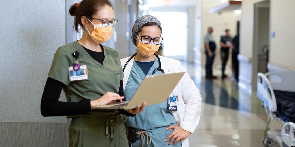 Internal medicine residents at Mayo Clinic in Florida look at a patient chart in the hospital hallway