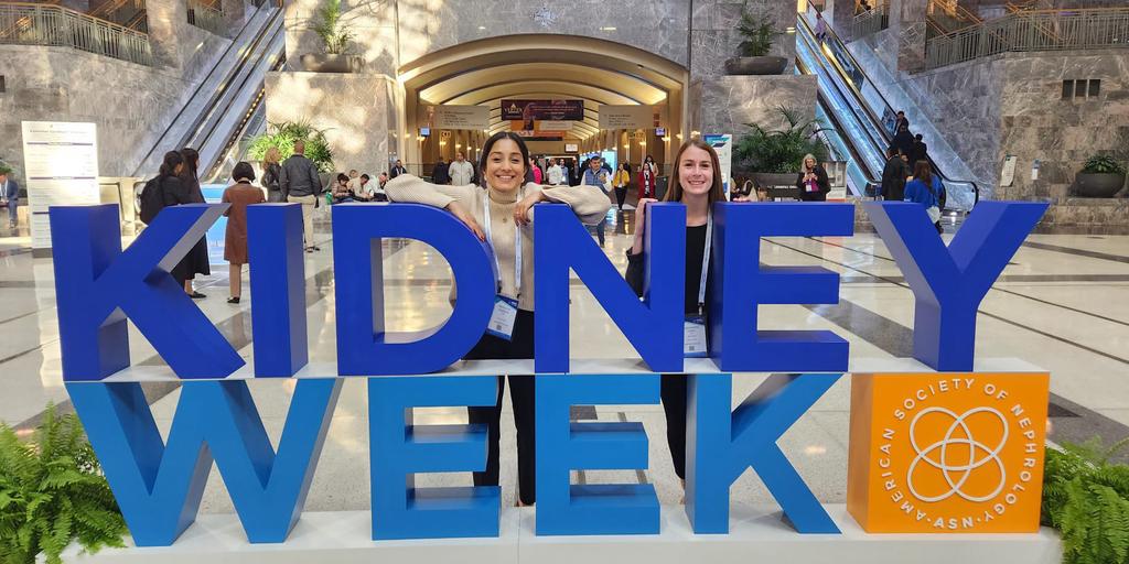 Dr. Koirala and Dr. Tomasi posing by a sign at the American Society of Nephrology’s Kidney Week Conference