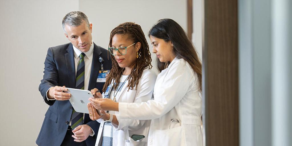 Nephrology medical professionals look at an iPad together.