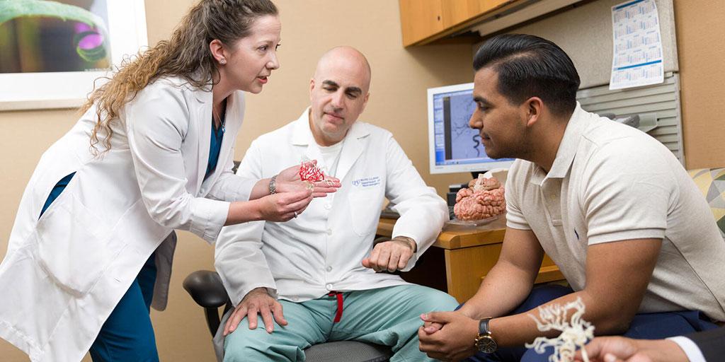 Neurologic surgery residents collaborating in a patient room