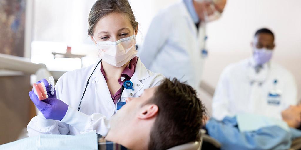 A person from the Orthodontics Residency at Mayo Clinic in Rochester, Minnesota, discussed with a patient a model of a mouth.