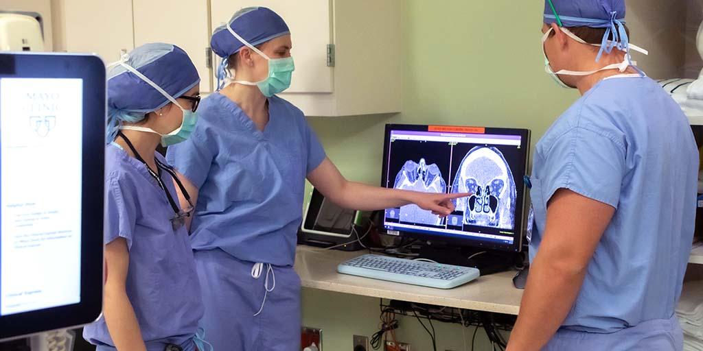 ENT physicians and residents exam a scan on the computer