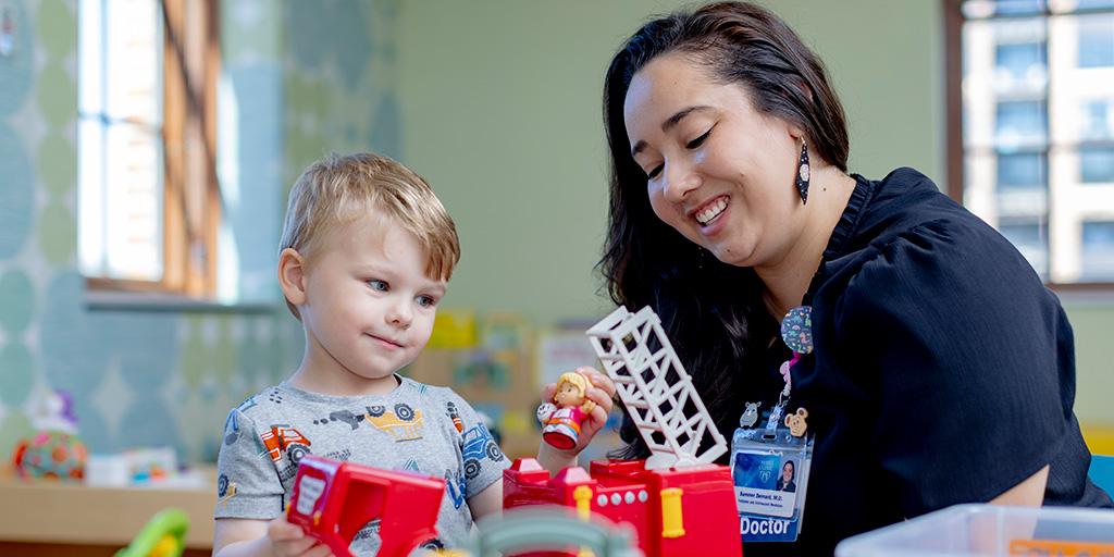 Doctor watching while youngster plays with toys