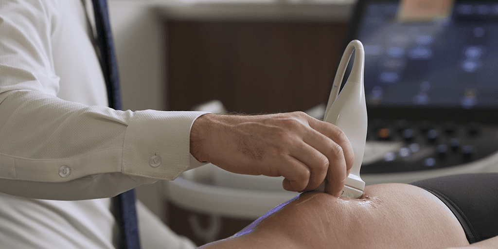 A doctor from PM&R Sports Medicine Fellowship program in Minneapolis, Minnesota, performing an ultrasound on the knee.
