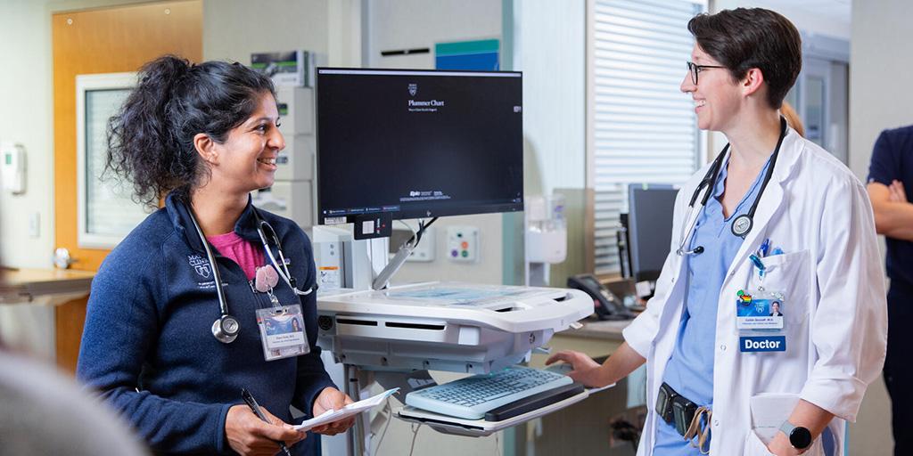 Two people from the Pulmonary Medicine Fellowship MN looking at computer