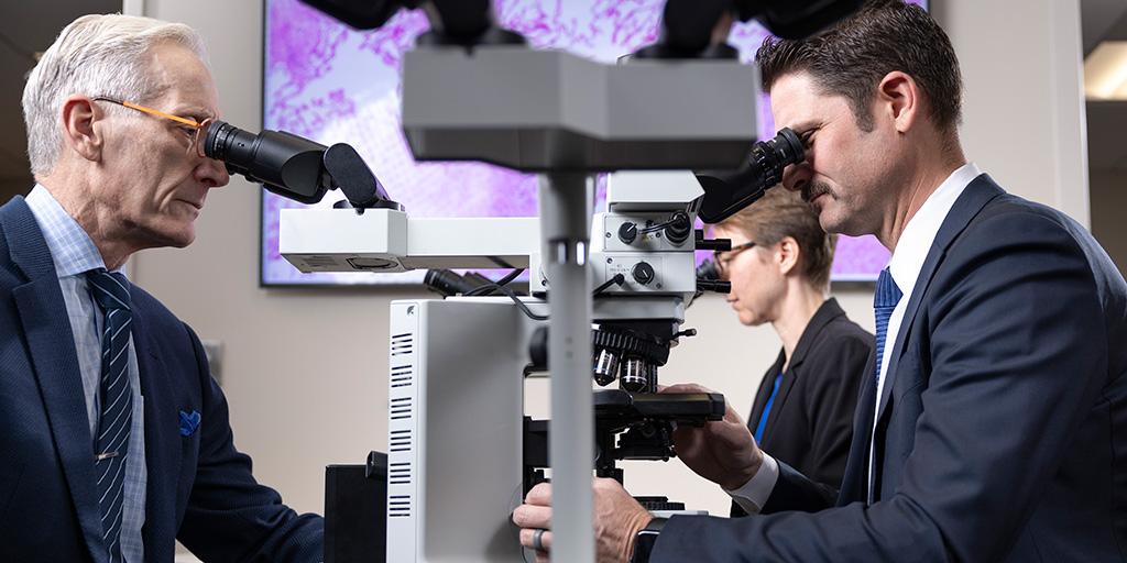 Three people from Pulmonary Pathology Fellowship looking through microscopies