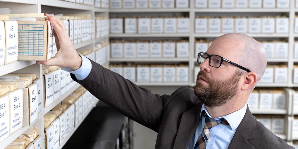 One person from Pulmonary Pathology Fellowship looking through file boxes