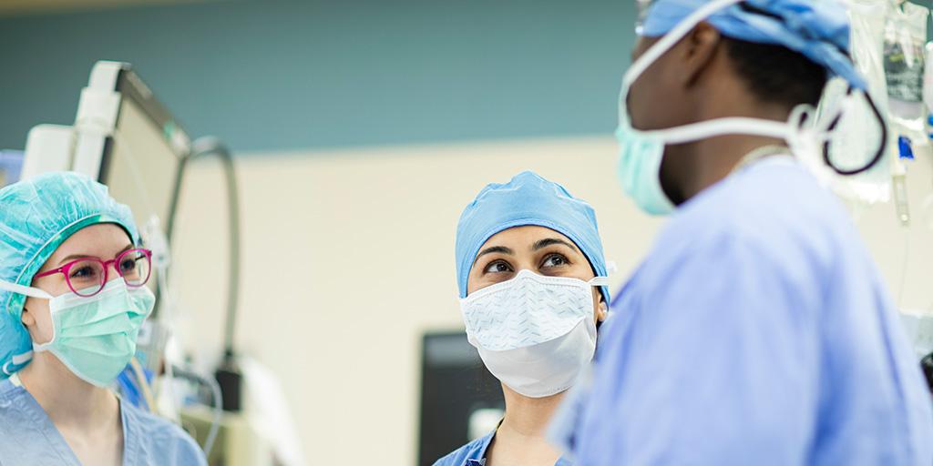 Rushna Ali, M.D. spoke with two colleagues in an operating suite.