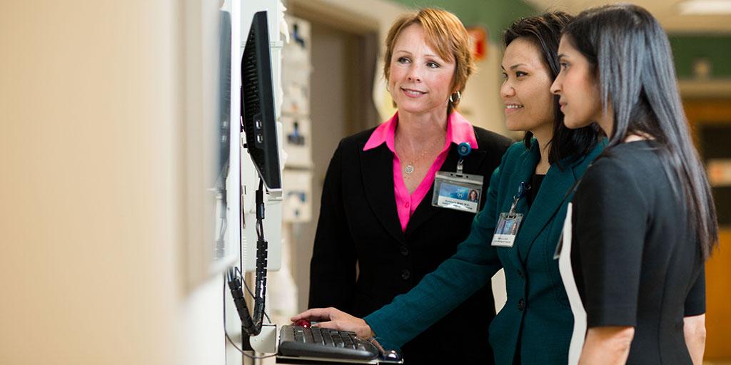 Transplant hepatologist Kymberly D. Watt, M.D., reviewing a patient's electronic medical record with fellows