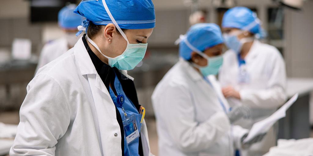 Elizabeth Olive, MD, and fellow urology residents reviewing instructions prior to Endoscopic Simulation Lab assignment.