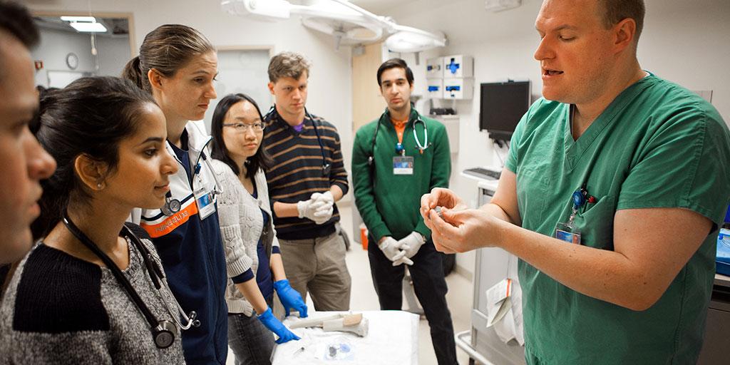 Medical students watching a demonstration from faculty member in simulation center