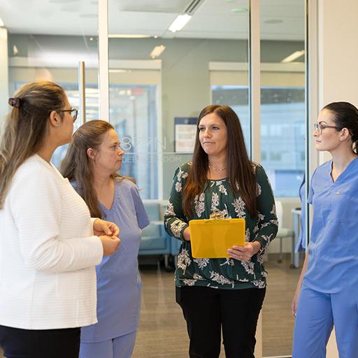 Four people from the Advanced Inflammatory Bowel Disease Fellowship program at Mayo Clinic in Jacksonville, Florida, gathered in a hallway for a discussion.