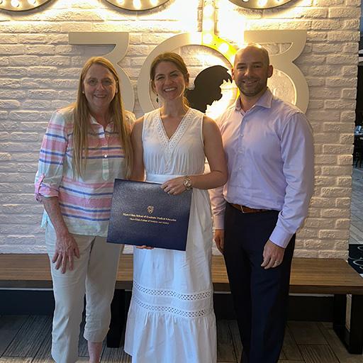 Our 2023 fellow graduate, Chanel Wood, M.D. (center) held their diploma and posed for a group photo with Program Director Patricia Mergo, M.D. (left) and Associate Program Director Justin Stowell, M.D. (right).
