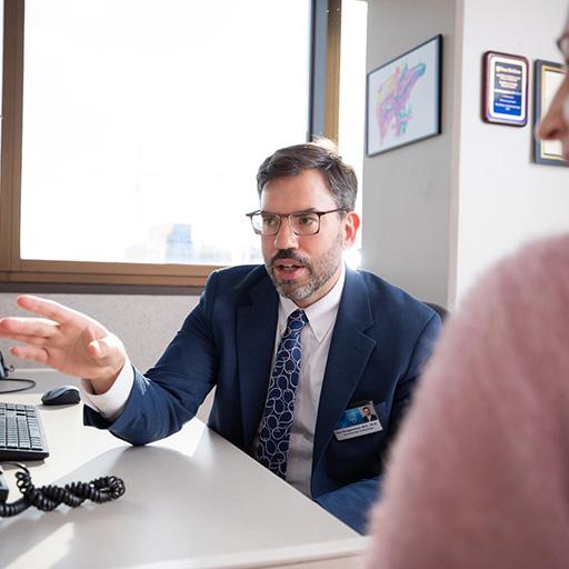 Kirk Wangensteen, MD, PhD, Gastroenterology and Hepatology consultant, works at his computer with a colleague