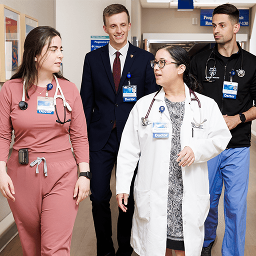 Physician speaking to residents in hallway